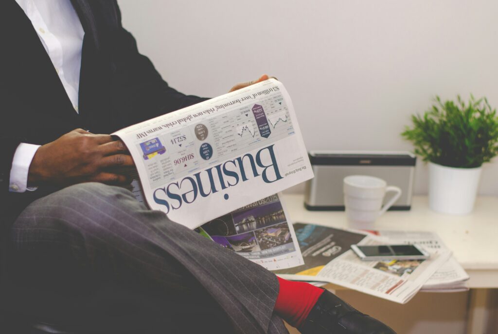 A men reading Business news paper regarding India's Top 05 Growing Industries in 2024